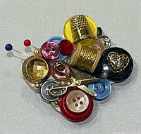 Front view showing all sewing notion elements on brooch