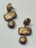 Front view of both brushed silver geometric dangle earrings