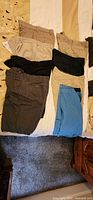 Six pairs men’s shorts laid out on bed showing colors and pocket styles