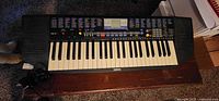 Top view of Yamaha PSR-78 keyboard on table with power adapter visible