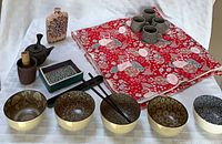 Group shot showing bowls, mugs, quilt, teapot, bottle, mortar, dish and chopsticks