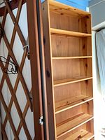 Full front view of tall knotty pine bookshelf
