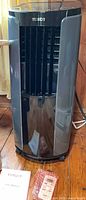 Front view of Tosot portable air conditioner tower with accessories at base