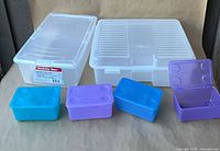 Group shot of all storage tubs: two clear large, three small colored