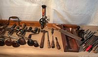 All tools laid out showcasing braces, level, mitre box, chisels, plane, files