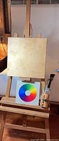 Full view of assembled wooden easel with board, color wheel and brushes
