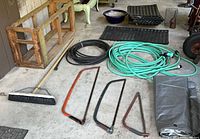 Entire lot overview showing saws, hoses, tarp, broom, tiles, pot, wire art