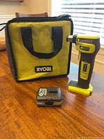 Auto hammer, battery and carrying bag on table