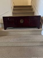 Full view of cabinet on stairs showing overall size, drawers, doors, legs
