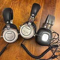 Both headphone sets showing ear cups and coiled cords