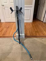 Full view of Aqua Joe stake faucet with blue hose attached