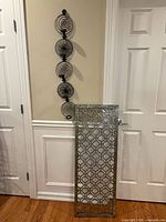 Both wall decor pieces shown together on wall and leaning against door