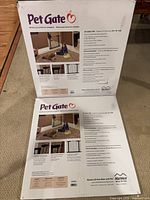 Front view of two boxed MidWest pet gates