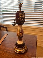 Full view of Reuge musical pepper mill showing wood top, porcelain stem, metal base