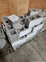 Stacked concrete blocks on pallet, showing hollow cores and painted faces