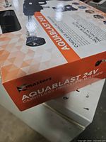 Front of boxed Masters Aquablast 24V cordless pressure washer