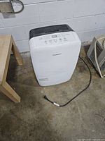Front view of white Garrison dehumidifier with power cord