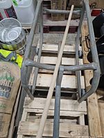 Top view of grey steel drum cart frame lying on wooden pallet