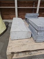 Two long precast sills and stack of pavers on pallet