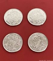 Four Canadian 50-cent coins lying on red background