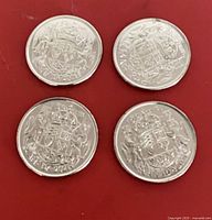 Four coins reverse showing coat of arms and dates