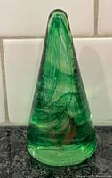 Front view of Kosta Boda glass Christmas tree showing green swirls