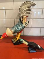 Both carved wooden bird sculptures side by side