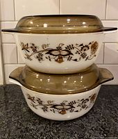 Stacked view of both Pyrex casseroles with lids showing pattern and shape