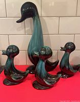 set of four Blue Mountain Pottery ducks on red surface