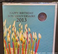 Front cover showing Happy Birthday 2013 text and visible coin