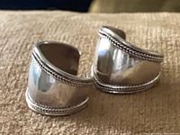 front view of both sterling silver earrings showing wide band and rope edge