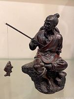 Full view of fisherman sculpture with pole and fish