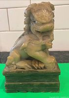 Front view of soapstone Foo dog statue on base