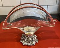 Front view of Murano glass napkin holder showing curved glass and ornate metal base