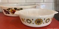 Side view of both casserole dishes showing patterns and size difference