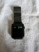 Front view of Apple Watch displaying charging indicator and time