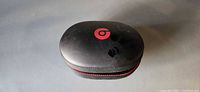 Closed hard case displaying red Beats logo