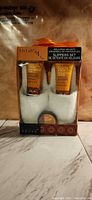 Front view of sealed LivLab Serengeti Sunset foot care set showing slippers, tubes, and salts jar