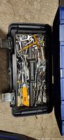 Open toolbox showing wrenches, ratchets, sockets, pliers, utility knife