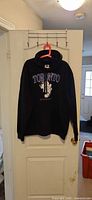 Full view of black Toronto Maple Leafs hoodie on hanger