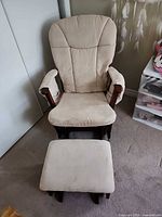 Front view of beige upholstered glider rocking chair and ottoman