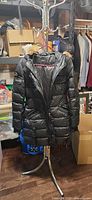 Full view of black Rudsak quilted coat hanging