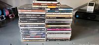 Two tall stacks of assorted CD jewel cases, spine titles visible