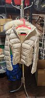 Front view of cream down puffer jacket on stand