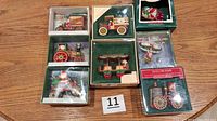 Eight boxed Hallmark Santa vehicle ornaments displayed on table