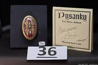 Brooch on display card with signed Pysanky card