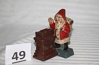 Front view Santa coin bank beside chimney, lot number card visible