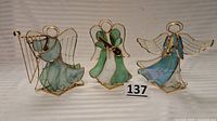 Three stained glass angel candleholders with instruments harp, violin, trumpet