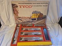 Overall view of Tyco set box with inner tray showing locomotives, passenger cars and track accessories