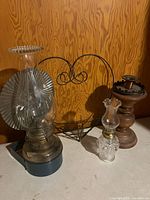 Group shot of oil lamps, wooden candlestick and wire wall basket